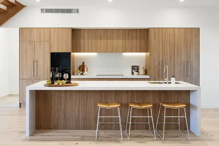 Open kitchen with timber island bench and three stools