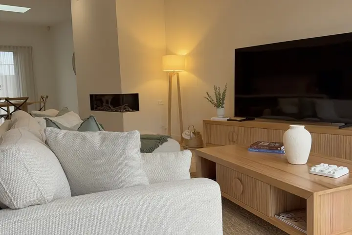 Light-filled living room with deep sofa and timber joinery