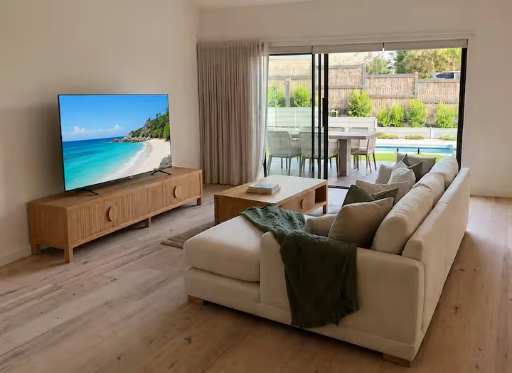 Light filled living room opening onto the outdoor dining area and pool